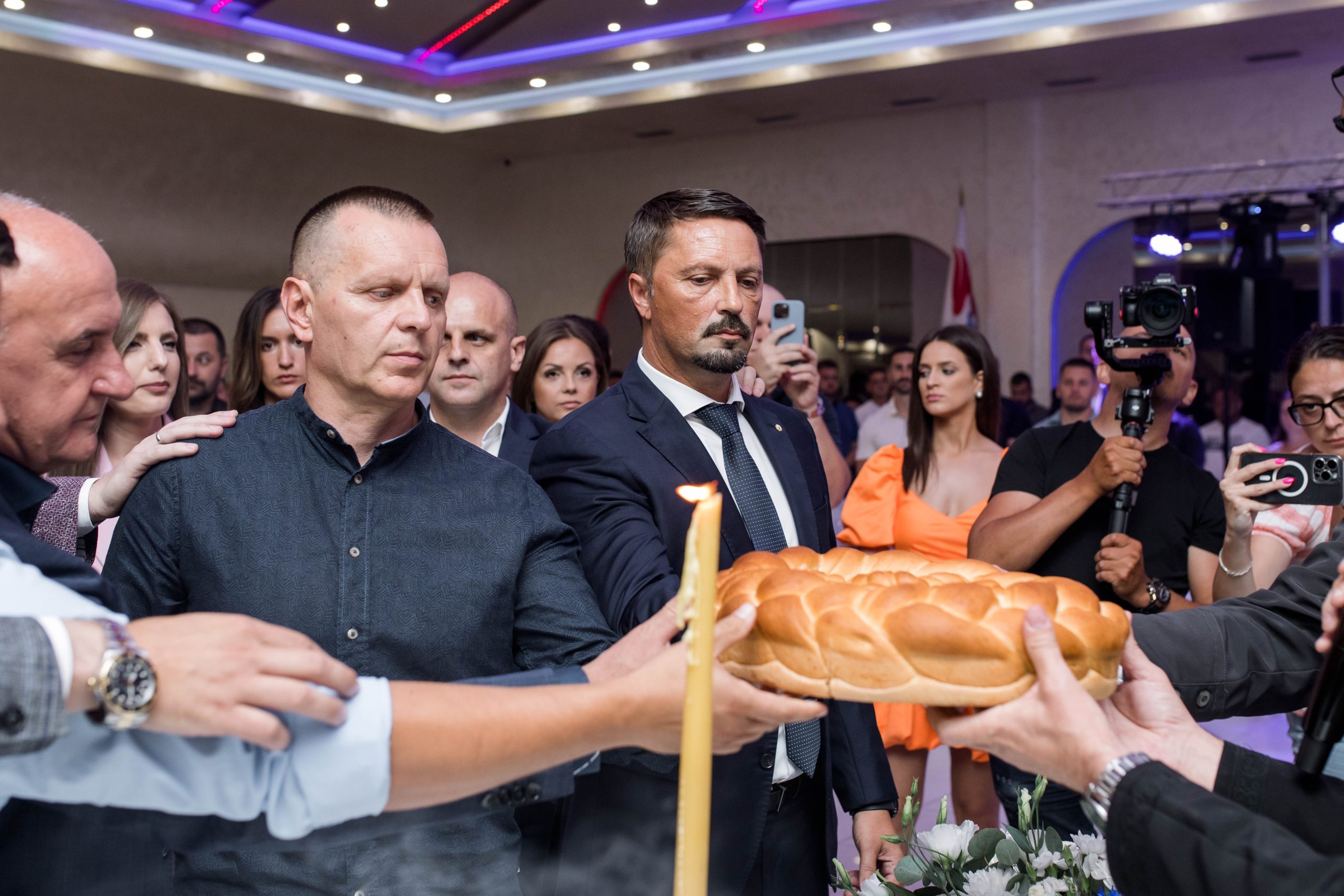 ljudi lome krsni kolac na Slavi